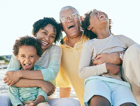 portrait of grandparents and their grandkids on the beach retirement future