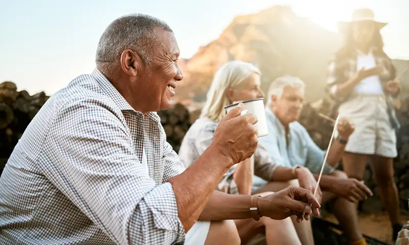 seniors having a cup of coffee together at camp site three core principles